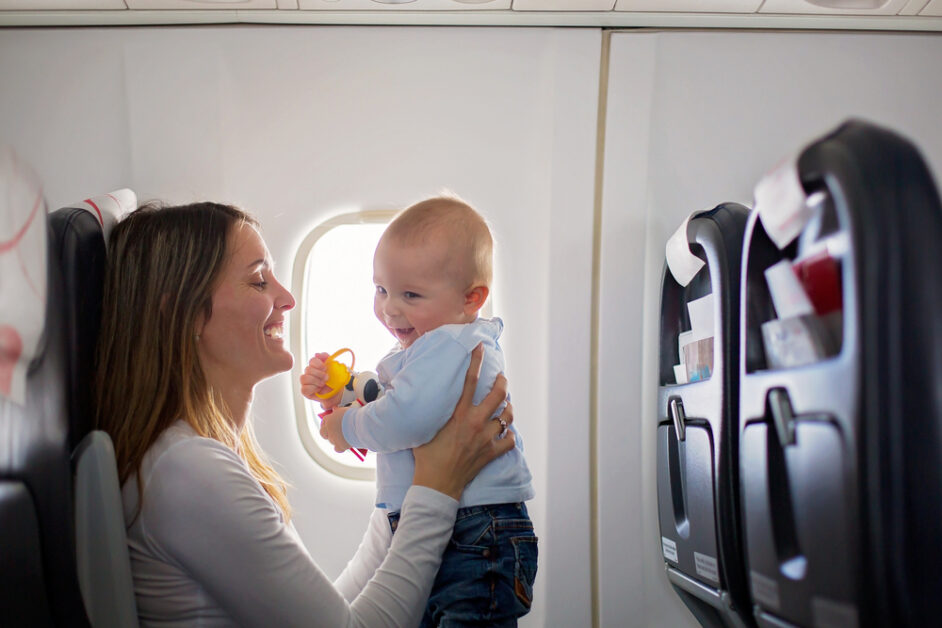Young mom, playing and breastfeeding her toddler on an aircraft