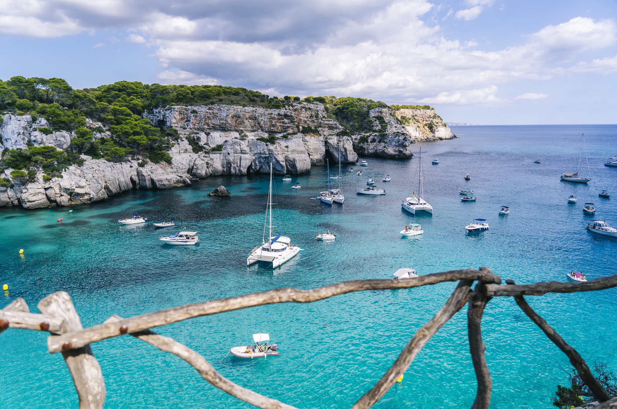 Panoramic view of Cala Macarelleta with people on their boats enjoying a day of vacation
