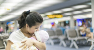 Mum holding a baby at the airport