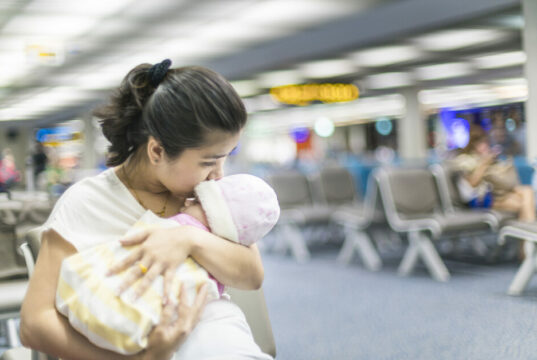 Mum holding a baby at the airport