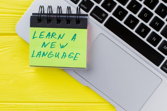 Laptop with a post-it where you can read "Learn a new language"