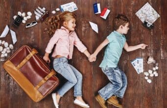 Children lying near travel related objects.