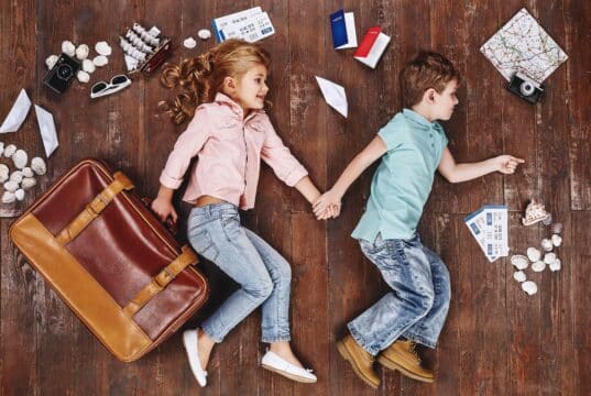 Travelling Abroad to Give Your Child the Best Language Exposure Children lying near travel related objects.